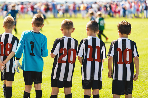 Children in Sports European Soccer Team. Kids in Striped Soccer Jersey Shirts Standing on the Grass Pitch. Boys in Football Game. Youth Football Players Play League Competition Match Outdoor