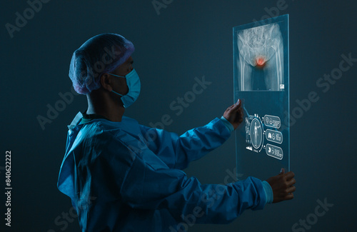 Doctor looking at total hip replacement X-ray film room at the hospital, healthcare concept.