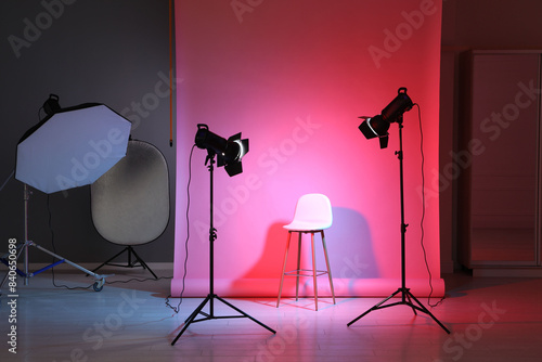 Photo background in neon lights and professional lighting equipment inside modern studio