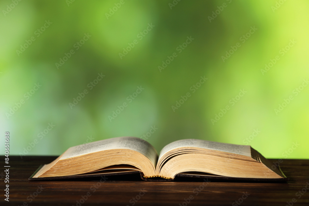 Bible on wooden table against blurred green background, space for text. Religion of Christianity Bible on wooden table against blurred green background, space for text. Religion of Christianity