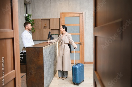 Canvas-taulu Female guests come with bags and suitcases to the hotel reception in the lobby