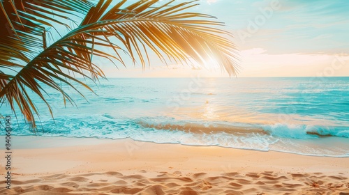 Palm tree branch framing a serene beach scene with turquoise waters and golden sand at sunset. Perfect for summer and travel themes.