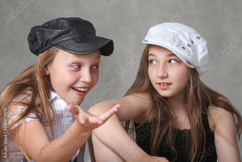 Konstfotografi two cute preteen girls having a chitchat  on grey background