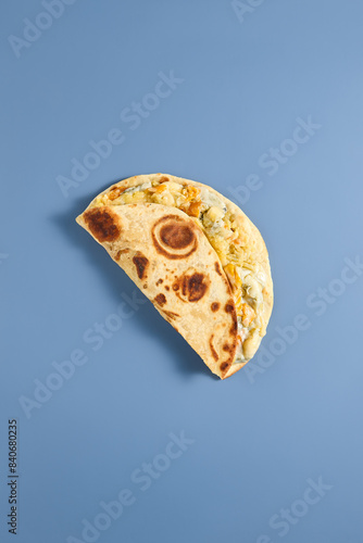 Traditional Eastern Flatbread Kystyby with Meat Filling on Blue Background photo