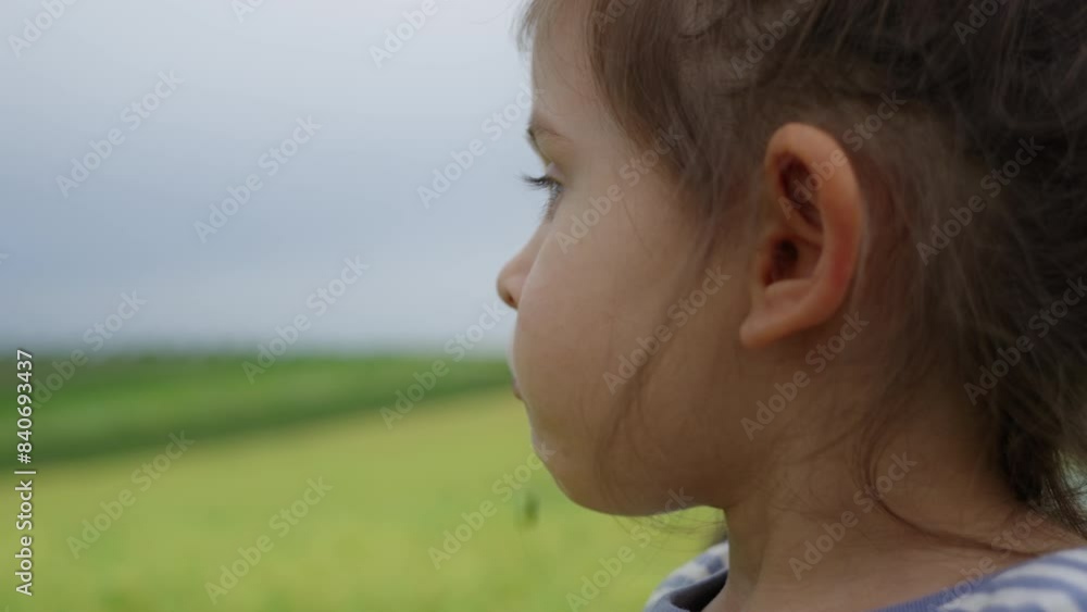 Girl in field, eating green bean, making faces, looking at sky and out window Girl in field, eating green bean, making faces, looking at sky and out window
