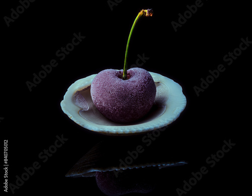 Cereza congelada en una concha de mejillón en fondo negro