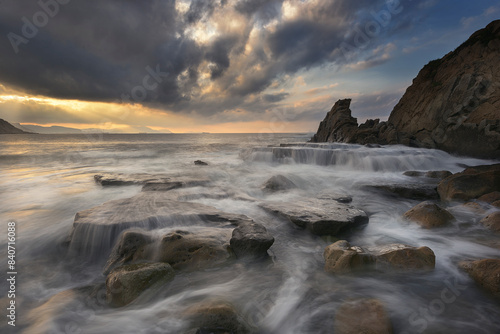 Fotografi Sunset with dramatic sky on Azkorri beach, Getxo