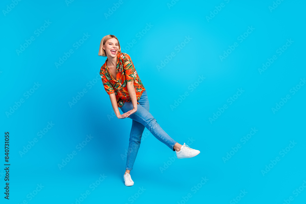 Photo of positive good mood girl wear trendy summer print clothes have fun dance isolated on blue color background Photo of positive good mood girl wear trendy summer print clothes have fun dance isolated on blue color background