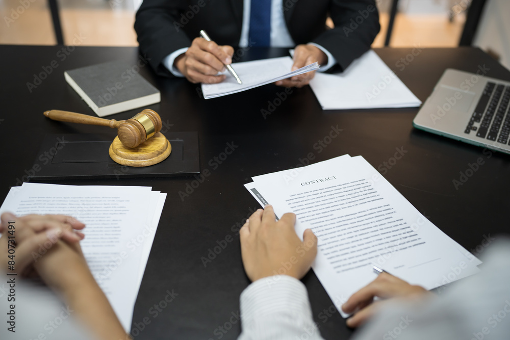 Legal counsel presents to the client a signed contract with gavel and legal law. justice and lawyer concept Legal counsel presents to the client a signed contract with gavel and legal law. justice and lawyer concept