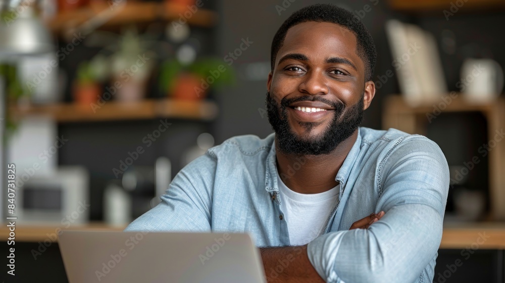 A man smiles confidently while working on his laptop in a cafe setting A man smiles confidently while working on his laptop in a cafe setting