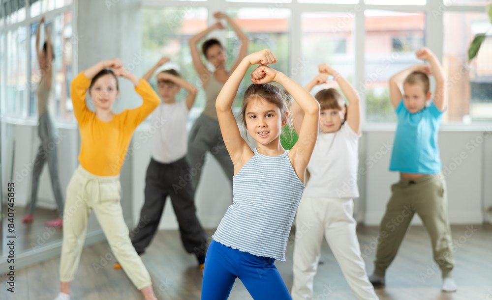 Fototapeta premium Group of boys and girls rehearsing modern dance in studio