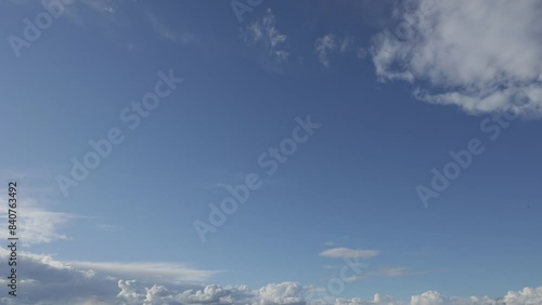 ampia visuale panoramica che mostra dal basso  il cielo azzurro, mentre piccole e sottili nuvole si muovono e cambiano, durante il giorno photo