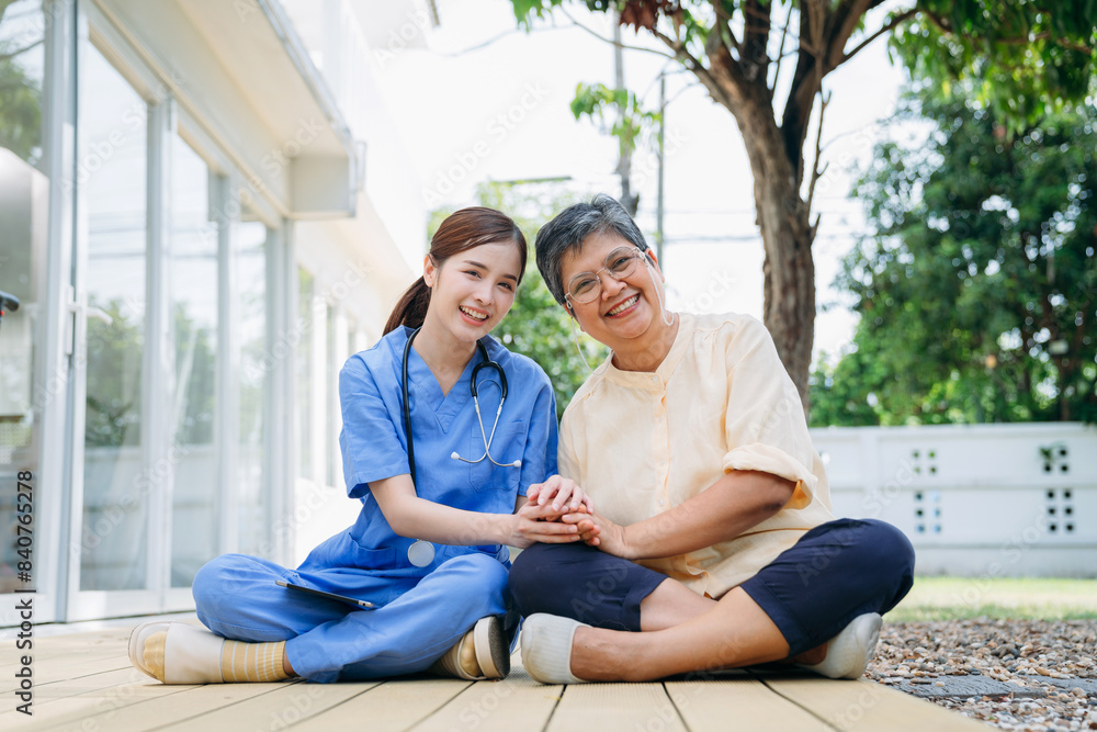 Fototapeta premium Nurse in a blue uniform is sitting on the ground with a woman in a yellow shirt.
