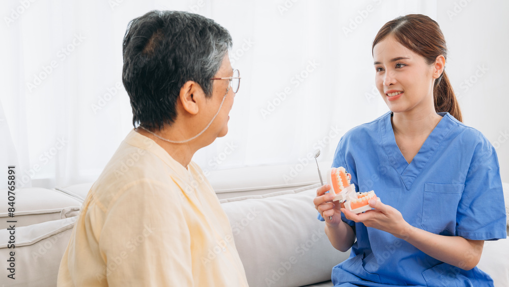 Female Dentist in a blue uniform is holding a toothbrush and talking to an older man Female Dentist in a blue uniform is holding a toothbrush and talking to an older man