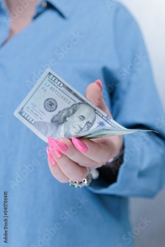 female hands holding American dollar paper bills