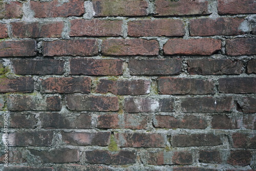 Abandoned mossy brick layered wall background, Grungy brick wall texture background, Weathered rusty brick backdrop photo