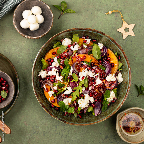 Warm winter quinoa salad with pumpkin, chorizo and mozzarella, arugula leaves and pomegranate.