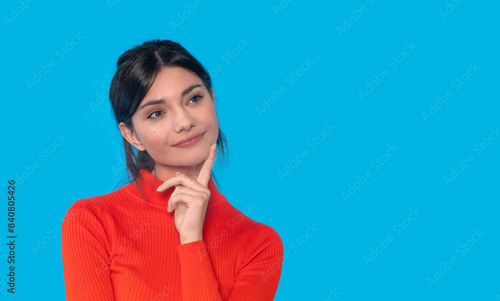 Thoughtful Woman in Red Sweater Against Blue Background Thoughtful Woman in Red Sweater Against Blue Background