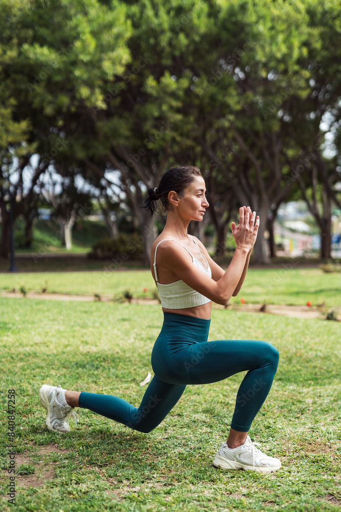 Brunette Woman Exercising in the Park on Grass Brunette Woman Exercising in the Park on Grass