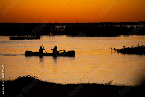 canoa con pescadores en el río en el atardecer