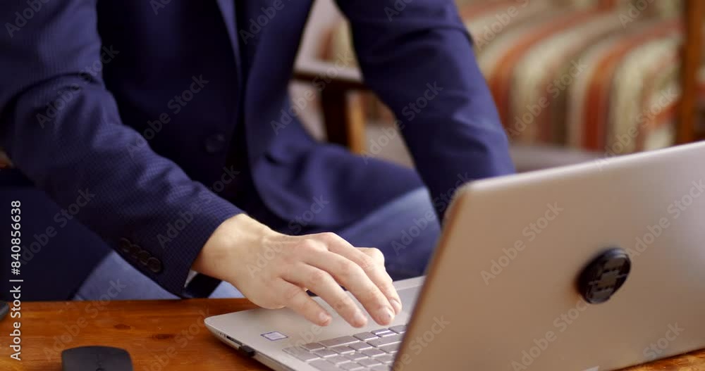 A young adult man in a business suit is working on a laptop at home and is worried about the result. Live camera effect A young adult man in a business suit is working on a laptop at home and is worried about the result. Live camera effect