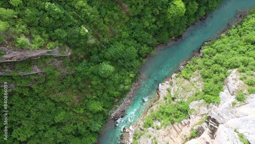 High angle view of zip line above canyon with turquoise river in the background High angle view of zip line above canyon with turquoise river in the background