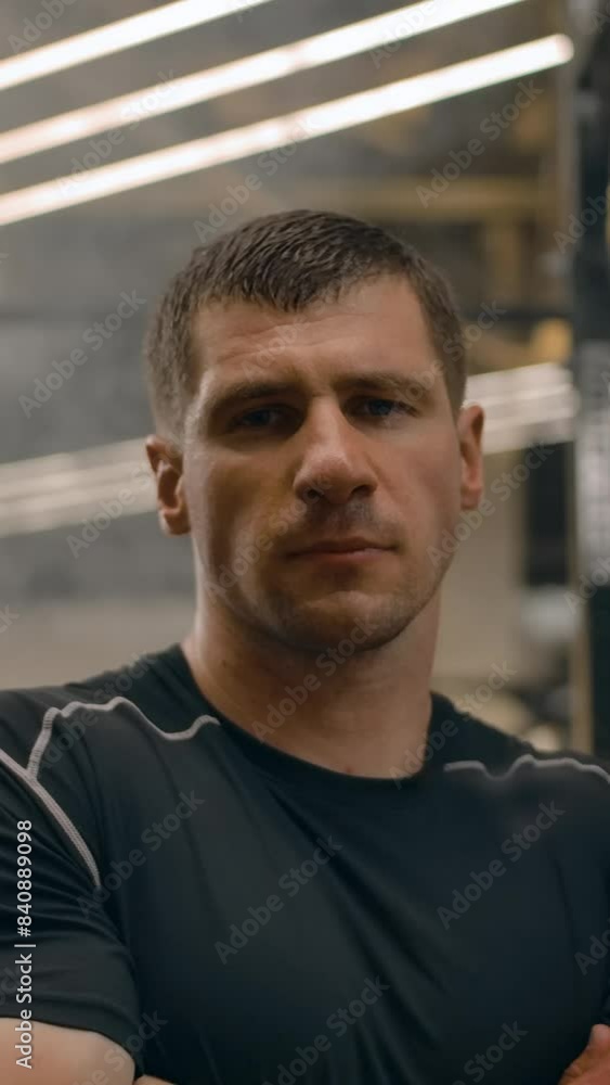 Portrait of a strong athletic man in a closed pose looking at the camera. Interior of a modern sports hall at sunset, professional studio lighting, serious epic decisive look. Vertical shot. Portrait of a strong athletic man in a closed pose looking at the camera. Interior of a modern sports hall at sunset, professional studio lighting, serious epic decisive look. Vertical shot.