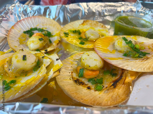 Grilled scallops shell with butter and garlic on white plate