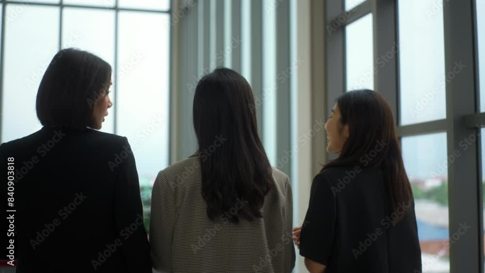 Rear view of young asian business woman talking with team while walking along hallway office and holding tablet checking information, young leader entrepreneur meeting with colleague startup business. Rear view of young asian business woman talking with team while walking along hallway office and holding tablet checking information, young leader entrepreneur meeting with colleague startup business.
