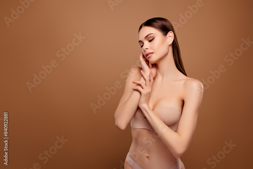 Photo of adorable sweet lady wear nothing closed eyes arm touch cheek empty space isolated brown color background