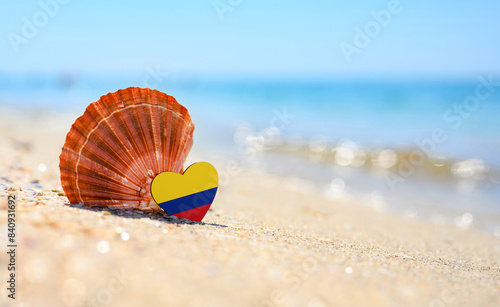 Sandy beach in Colombia. Flag of Colombia in the shape of a heart and a large shell. A wonderful resort