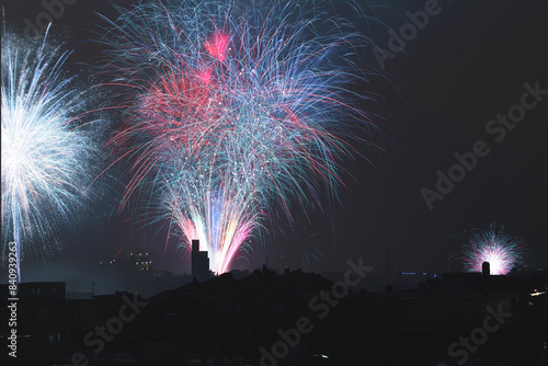 primo piano su tanti e colorati fuochi d'artificio, che esplodono nell'aria, di sera, nella nebbiosa città di Trieste, nel nord est Italia, per festeggiare la fine dell'anno photo