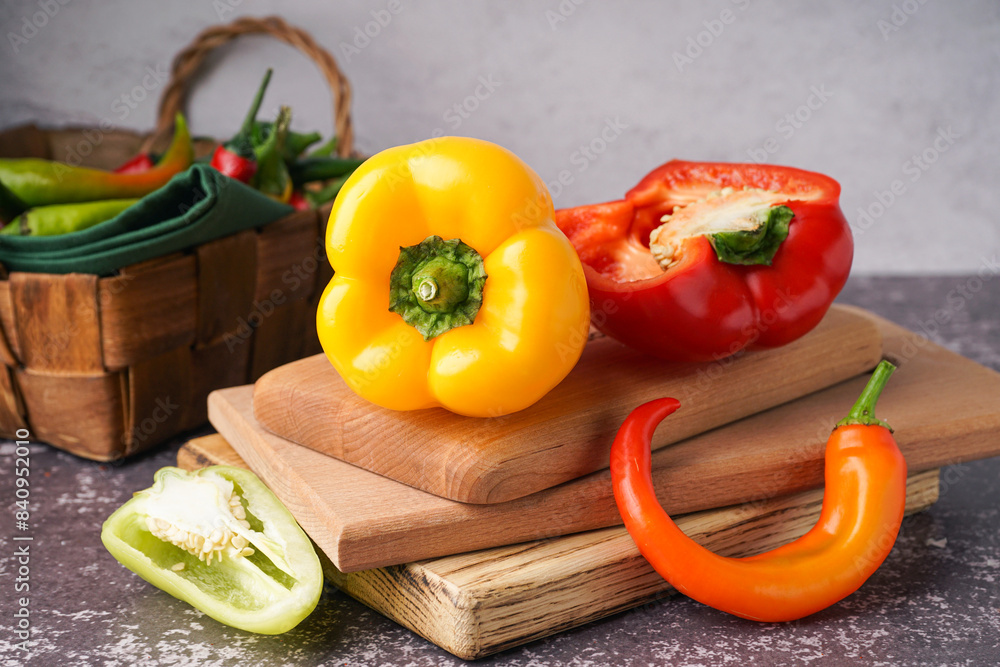 Wooden board with different fresh peppers on dark table Wooden board with different fresh peppers on dark table