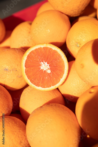 display of oranges in a market, one orange cut in half.