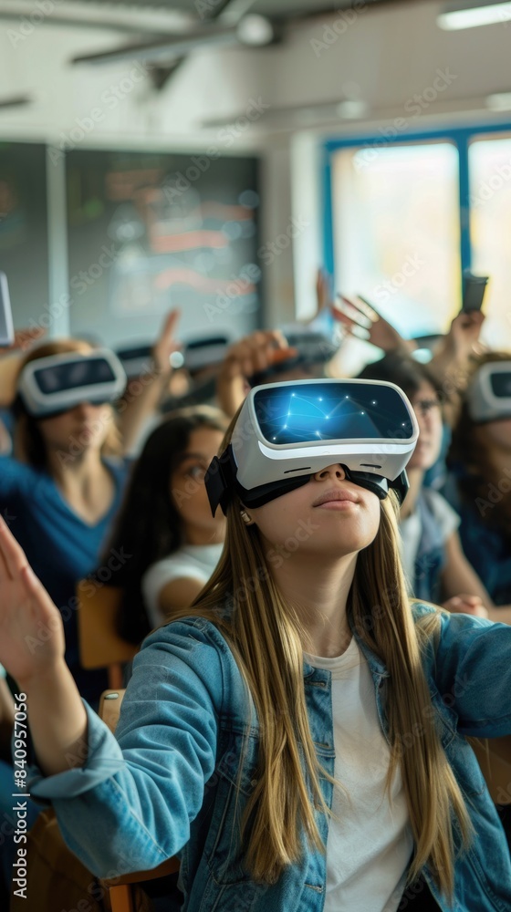A young woman wearing a virtual reality headset looks up in awe as she experiences a virtual world. She is sitting in a classroom setting with other students, all of whom are also wearing VR headsets