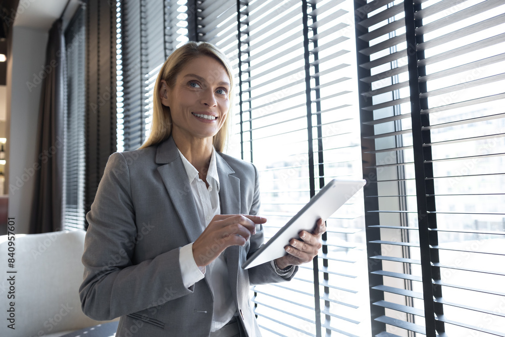 Confident business leader using tablet in office interior Confident business leader using tablet in office interior