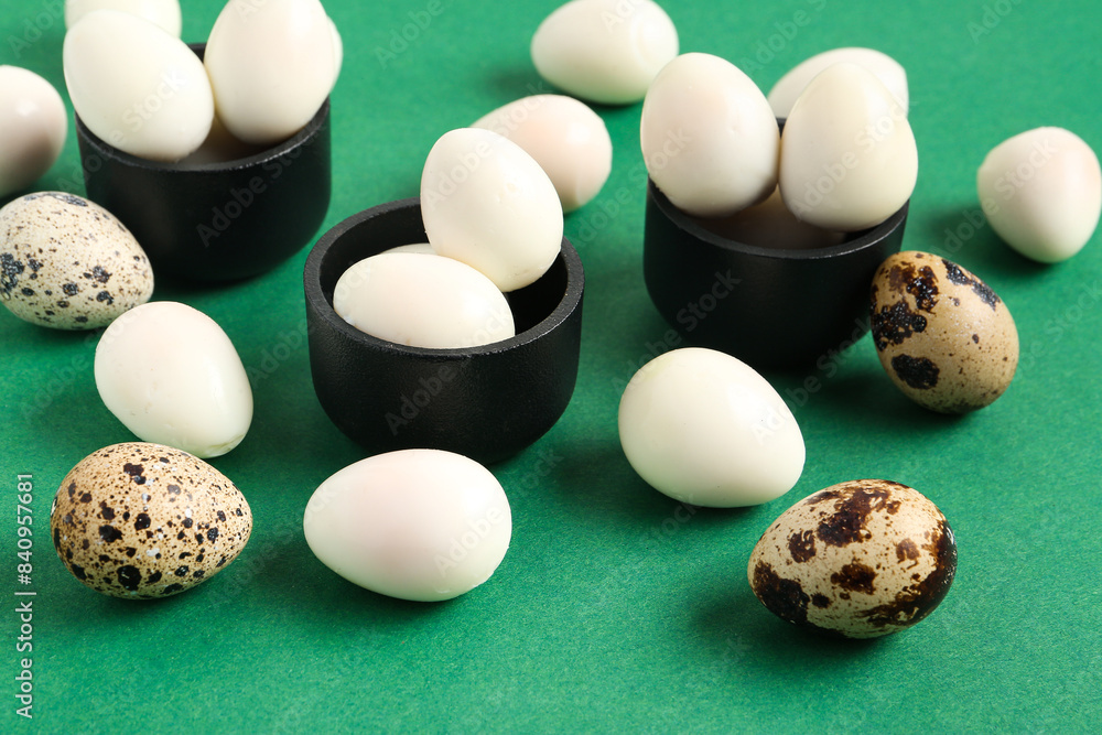 Bowls with fresh boiled quail eggs on green background Bowls with fresh boiled quail eggs on green background