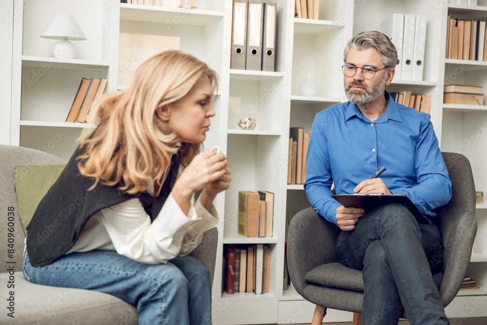 Fototapeta premium Man psychologist discusses solutions and support with her troubled female patient in his office