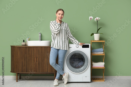Young woman near washing ma...