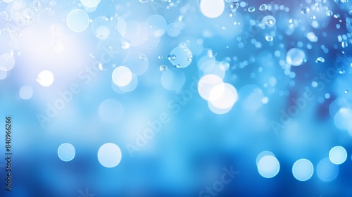 Abstract blue bokeh background with blurred lights. Perfect for festive, holiday, or celebratory designs requiring a soothing ambiance.