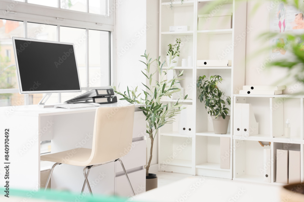 Interior of medical office with doctor's workplace, shelf units and plants Interior of medical office with doctor's workplace, shelf units and plants
