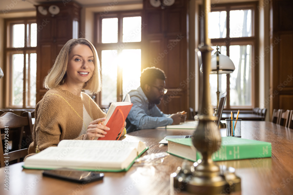 Young man and woman studying in the library ad looking focused Young man and woman studying in the library ad looking focused