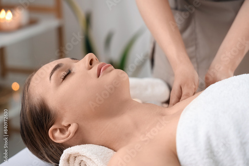 Young woman getting shoulder massage in spa salon, closeup