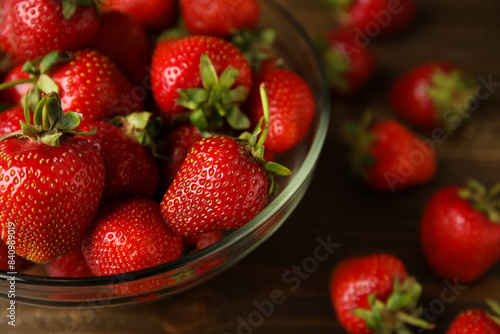 Glass bowl with sweet fresh strawberries on wooden background