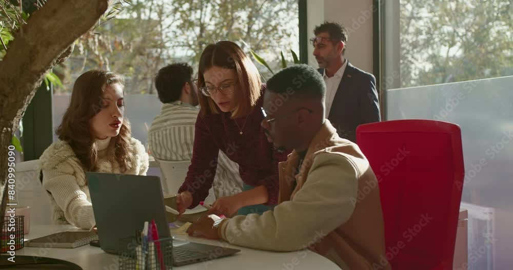In a brightly lit office, a mixed race group of employees engages in a detailed analysis, using charts and digital devices to discuss business growth and strategies. In a brightly lit office, a mixed race group of employees engages in a detailed analysis, using charts and digital devices to discuss business growth and strategies.