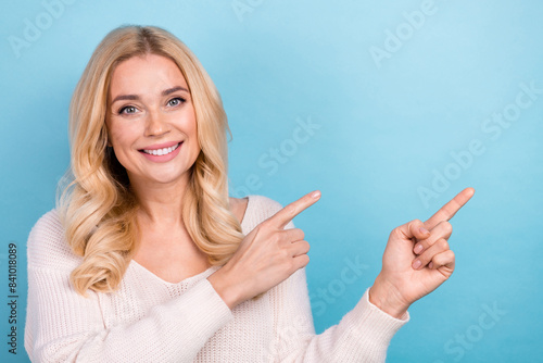 Photo of lovely nice woman wear stylish white clothes demonstrate empty space isolated on blue color background