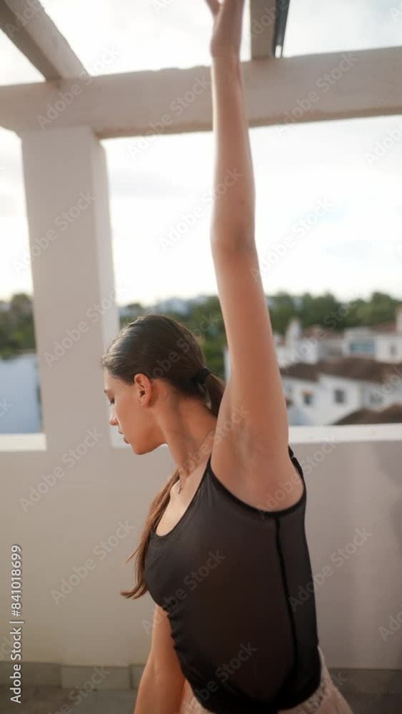 A young ballerina practices dance on a sunny balcony with elegance in her contemporary performance A young ballerina practices dance on a sunny balcony with elegance in her contemporary performance