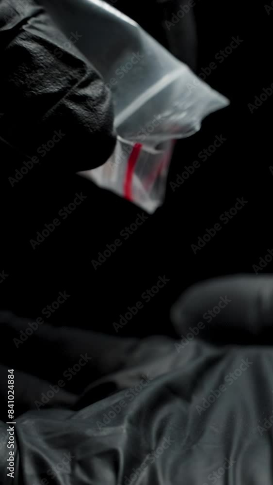 Vertical video. From a Small Packet onto the Palm of a Hand in Black Gloves Falls a Pulled-out Human Tooth. Vertical video. From a Small Packet onto the Palm of a Hand in Black Gloves Falls a Pulled-out Human Tooth.