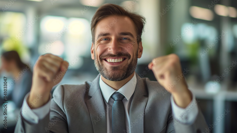 caucasian businessman throwing fist in the air sitting in office working laptop, from good news, in excitement, happiness for winning, achieving and celebrating caucasian businessman throwing fist in the air sitting in office working laptop, from good news, in excitement, happiness for winning, achieving and celebrating