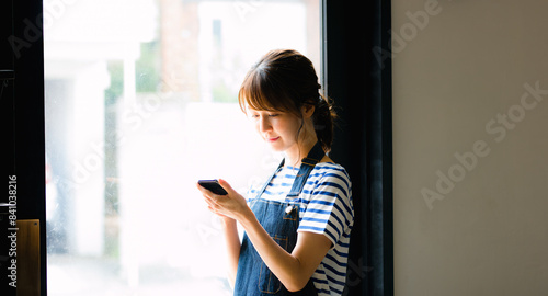 Free Download スマホを見る女性カフェ店員 - GFXLoad